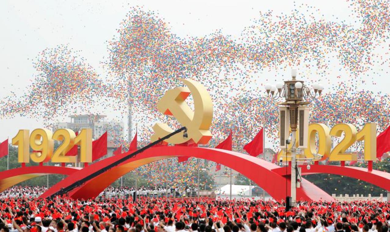 中国共产党成立100周年庆祝大会的参与者挥舞国旗和党旗