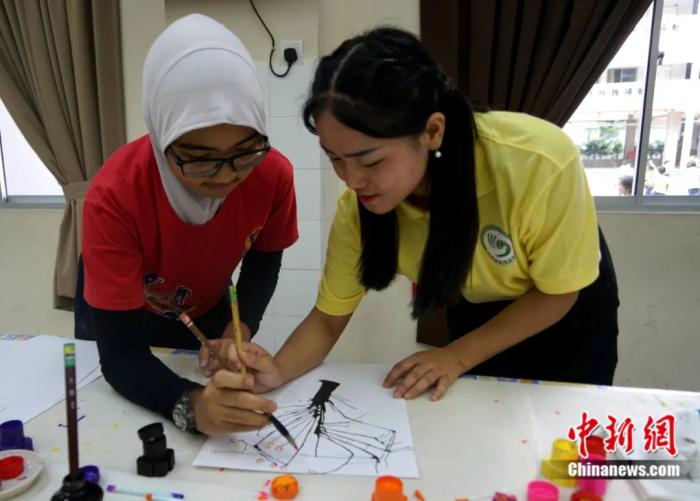 马来西亚世纪大学孔子学院的中国老师辅导马来裔学生学习中国水墨画